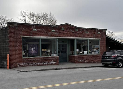 single story brick storefront on street with big windows. 